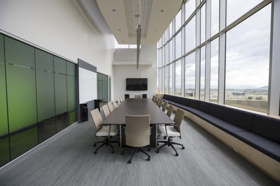 A meeting room with a long table and chairs